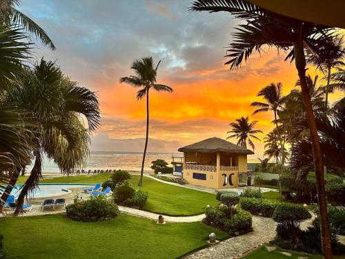 a view of a resort with a pool and palm trees at Agualina Kite Hotel Oceanfront Apartments in Cabarete