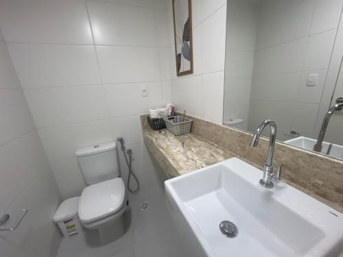 a white bathroom with a toilet and a sink at Stella Maris Vista de Cima in Salvador