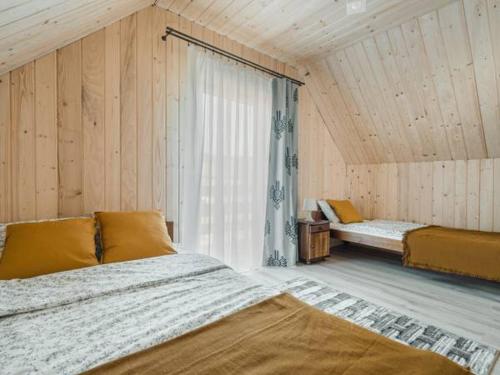 Cette chambre comprend deux lits et une grande fenêtre. dans l'établissement Spiska Chatka, à Kacwin