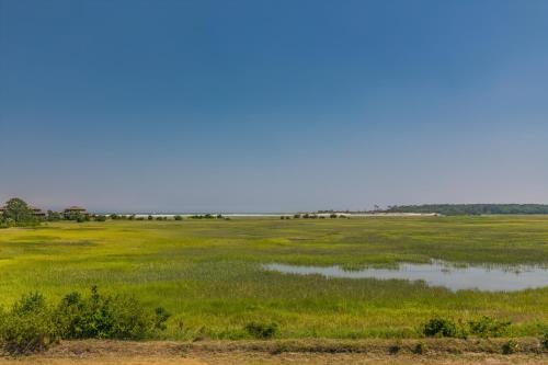 a field of grass with a large body of water at NEW LISTING! Two Bedrooms in A Building with Marsh and Ocean Views in Harbor Island