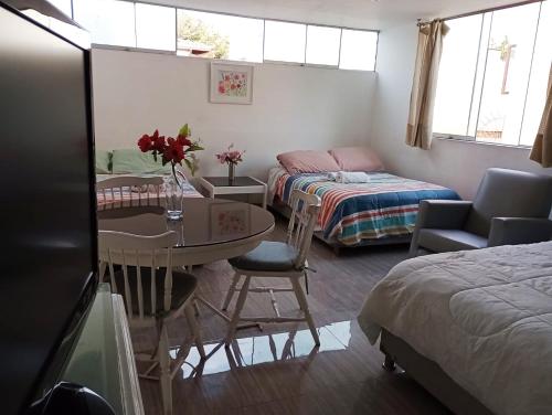 a room with a bed and a table and a bed and a room at Monterrico Suites Hotel in Lima