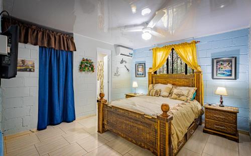1 dormitorio con 1 cama con paredes azules y cortinas azules en Casa de Estadía Verdún, en San José de Las Matas