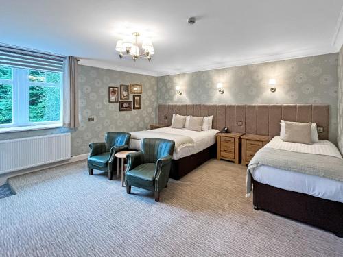 a hotel room with two beds and a table and chairs at The Atholl Palace in Pitlochry
