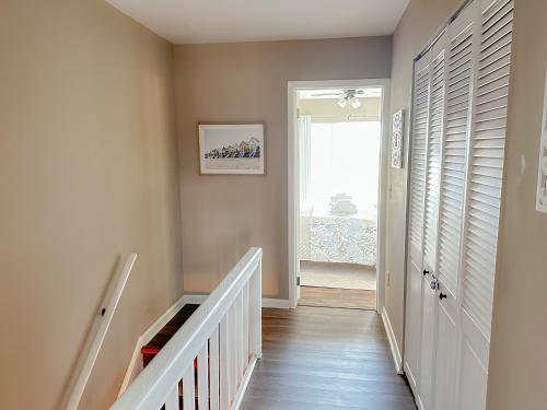 a hallway with stairs and a door with a window at Panoramic Marsh and Ocean Views. Steps to Beach and Pool. in Harbor Island