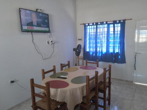 Habitación con mesa con sillas y TV. en Km 9 en Viedma
