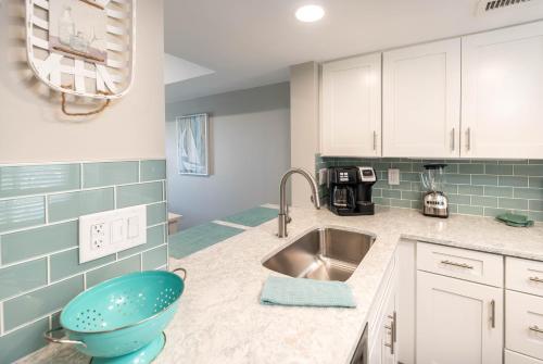 a kitchen with a sink and a bowl on the counter at Newly Listed Immaculate Condo - Distant Ocean Views - Pool and Beach Access in Harbor Island