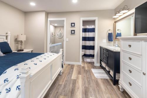 a bedroom with a white bed and a bathroom at Newly Listed Immaculate Condo - Distant Ocean Views - Pool and Beach Access in Harbor Island