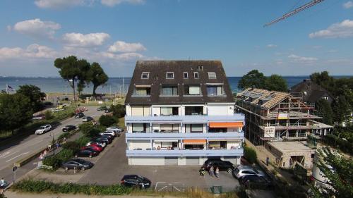 a building on a street with cars parked in a parking lot at Apartmenthaus Seetempel in Scharbeutz