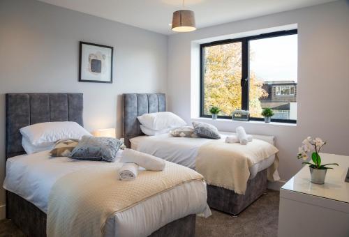 1 Schlafzimmer mit 2 Betten und einem Fenster in der Unterkunft Hendon Luxury Home 1 in Hendon