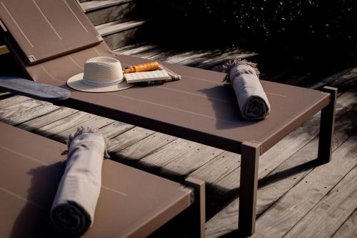 a table with a hat on top of a wooden deck at Eden Roc Villas in Le Diamant