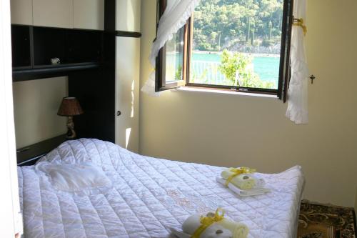 Schlafzimmer mit einem Bett mit weißer Bettwäsche und einem Fenster in der Unterkunft Apartment Ombla in Mokošica