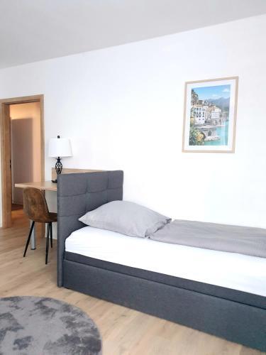 a bedroom with a bed and a desk with a picture on the wall at Zur Elster 2 in Plauen
