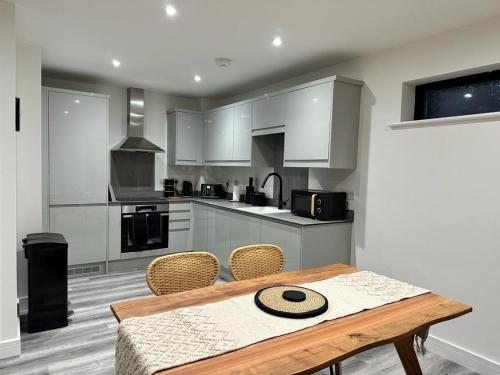 a kitchen with a wooden table and chairs at 2 Ashbrook Margaret - luxury 2 bed ground floor in Oxford