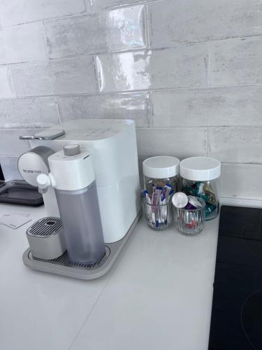 a counter with a coffee maker and containers on it at Cosea Langebaan in Langebaan