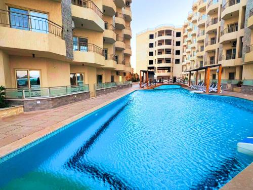 Beach Front Apartment in Hurghada La Quinta Beach Compound في الاسماعلية: مسبح كبير امام بعض مباني الشقق