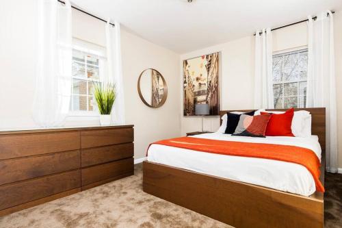 Un dormitorio con una cama grande y un espejo. en Perfect for family visits to Washington DC or UMD!, en College Park
