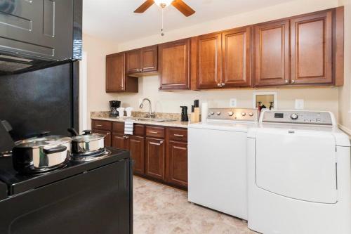 a kitchen with white appliances and wooden cabinets at Perfect for family visits to Washington DC or UMD! in College Park