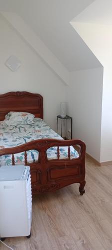 - une chambre avec un lit doté d'un cadre en bois dans l'établissement CHAMBRE AU CLOS DU BOIS 44110 CHATEAUBRIANT, à Châteaubriant