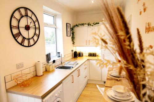 a kitchen with a sink and a clock on the wall at Elite 49 Stays in Newcastle upon Tyne