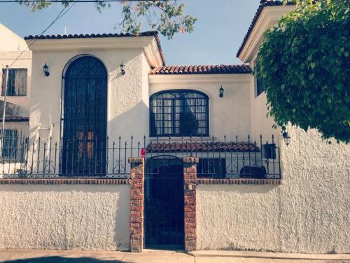 ein weißes Haus mit einem Tor und einem Zaun in der Unterkunft Posadas nido del tecolote in Guadalajara