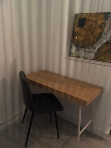 un escritorio de madera con una silla junto a la pared en La Mulhousienne de France, en Mulhouse