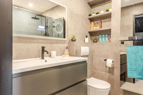 une salle de bain avec un lavabo, des toilettes et un miroir dans l'établissement Plage luxe collé à l’hôtel Martinez, à Cannes