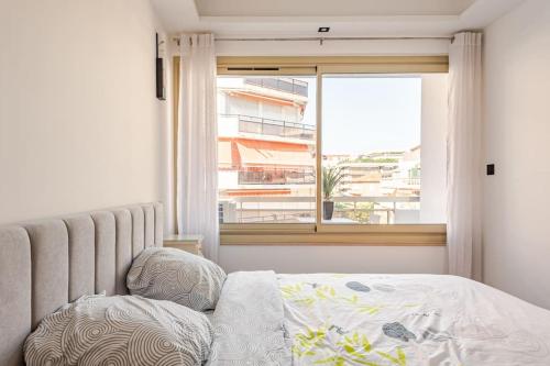 - une chambre avec un lit et une fenêtre avec un bâtiment dans l'établissement Plage luxe collé à l’hôtel Martinez, à Cannes