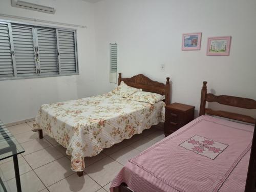 1 Schlafzimmer mit 2 Betten, einem Fenster und einem Tisch in der Unterkunft Casa para temporada primavera na canastra in São Roque de Minas