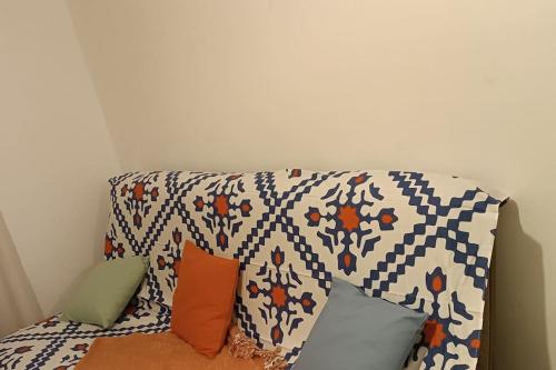 un sofá con almohadas en una habitación en Duplex lumineux & Wifi Netflix, en Roubaix