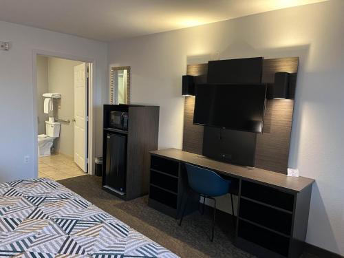 a hotel room with a bed and a desk with a television at Motel 6 Junction, TX Llano River in Junction