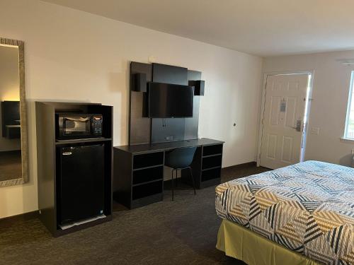 a hotel room with a bed and a desk with a television at Motel 6 Junction, TX Llano River in Junction