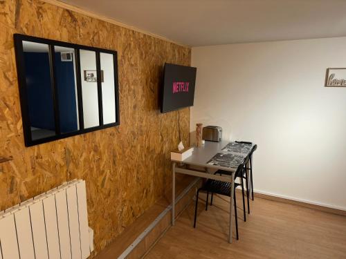 Studio proche forêt في ممورنسي: غرفة مع طاولة ونافذة على الحائط
