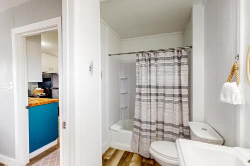 y baño blanco con aseo y ducha. en Summer Blues Bungalow, en Aransas Pass