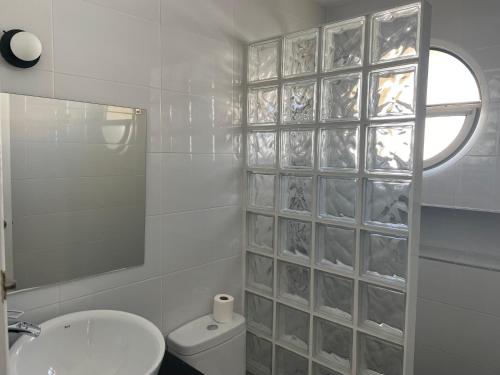 a bathroom with a toilet and a sink and a window at Apartamento Rota in Rota