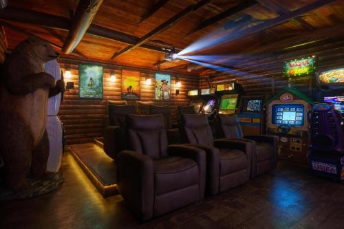 ein Videospielzimmer mit Stühlen und Videospielautomaten in der Unterkunft Great Outdoors: Arcade, Golf, Theater, Sauna @more in Garden Grove