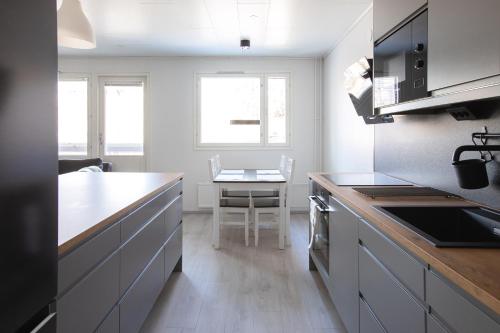 una cocina con encimera y mesa. en Kaksio hyvällä paikalla & ilmainen parkki+wifi, en Lappeenranta