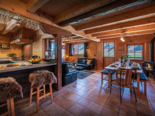une cuisine et un salon avec une table et des chaises dans l'établissement Chalet Capieu - Le Barn - OVO Network, à Manigod