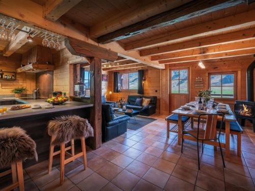a kitchen and living room with a table and chairs at Chalet Capieu - Le Barn - OVO Network in Manigod