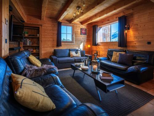 a living room with leather couches and a table at Chalet Capieu - Le Barn - OVO Network in Manigod