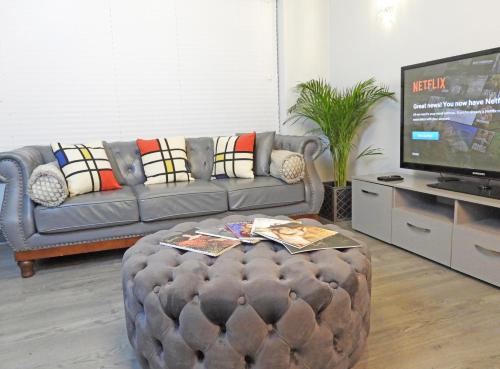 a living room with a couch and a tv at A Home from Home - Leamington Spa in Leamington Spa