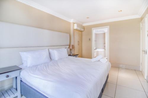 a bedroom with a large white bed with a night stand at Stunning Sails on Point C208 in Durban