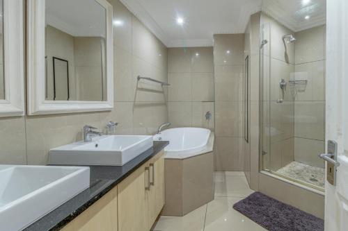 a bathroom with two sinks and a shower at Stunning Sails on Point C208 in Durban