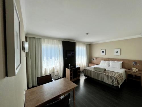 Habitación de hotel con cama y escritorio en Suite executiva reformada dentro do hotel Radisson en São Paulo