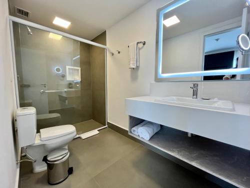 a bathroom with a toilet and a sink and a shower at Suite executiva Park in Radisson Berrini Luxo Queen 17 in Sao Paulo