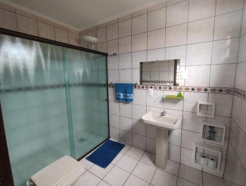 ein Bad mit einer Dusche, einem WC und einem Waschbecken in der Unterkunft HAPPY HOSPEDAGENS CASA 1 in Cascavel