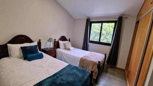 ein kleines Schlafzimmer mit 2 Betten und einem Fenster in der Unterkunft Casa da Levada do Arco in Arco da Calheta