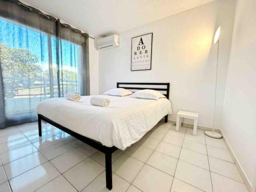 une chambre avec un lit et une grande fenêtre dans l'établissement Le Maeva : Apt 4 Prs, Clim, Garage, piscine, à Antibes