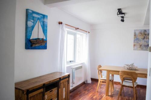 une salle à manger avec une table et un voilier sur le mur dans l'établissement Dpto. Centrico con Vista al Lago, à San Carlos de Bariloche