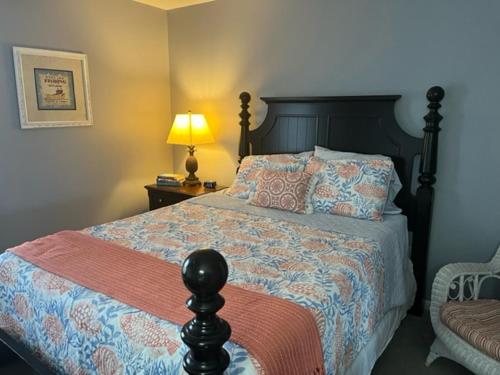 a bedroom with a bed and a lamp and a chair at NEW LISTING! Centrally Located with Pool and Beach Views in Harbor Island