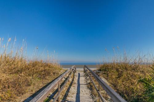 a wooden path leading to the beach at NEW LISTING! Centrally Located with Pool and Beach Views in Harbor Island